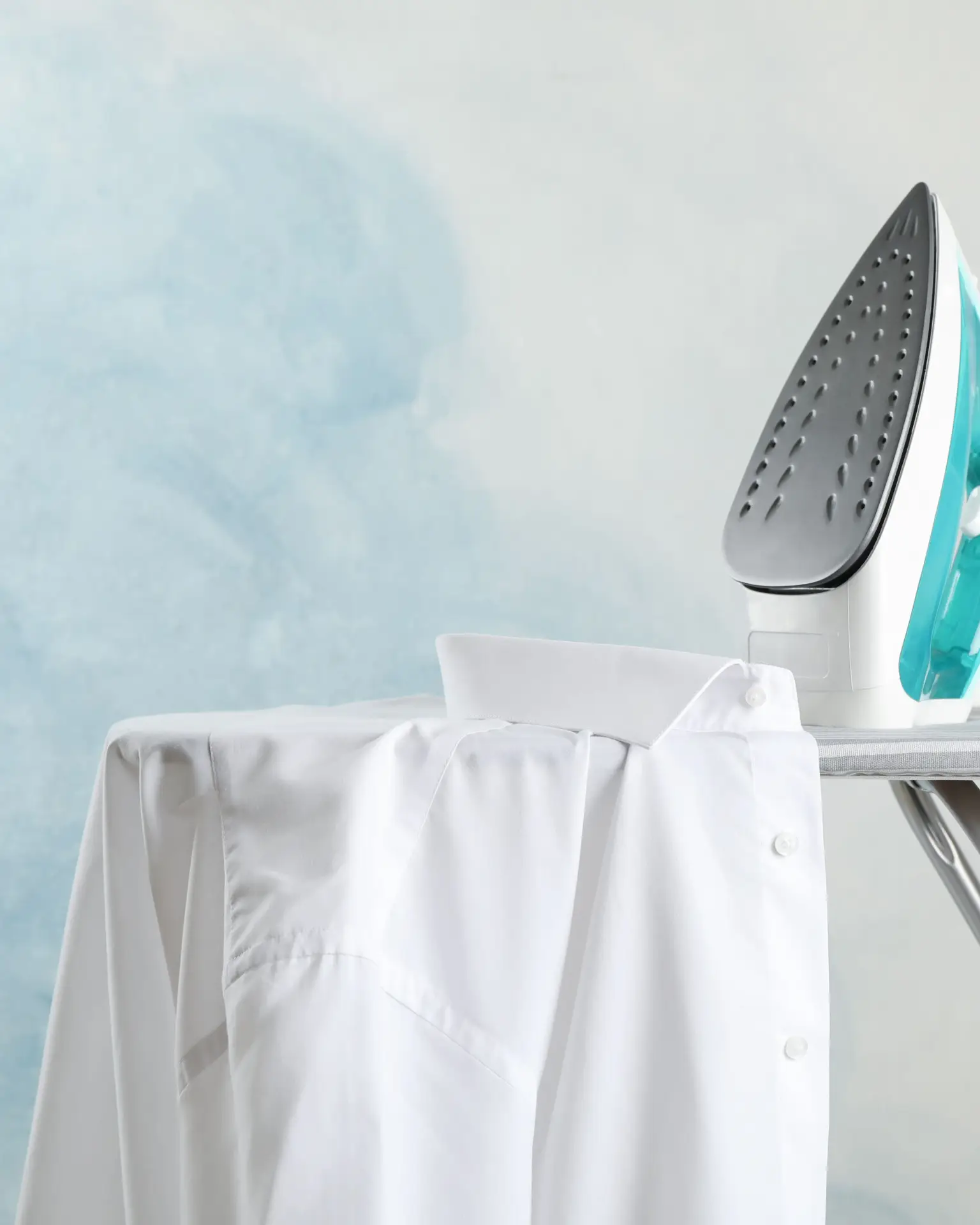 Iron & Shirt for Textile Design & DIY T-Shirt Printing Electric iron on ironing board with white shirt – ideal for fixing transfer prints and fabric paints on T-shirts.