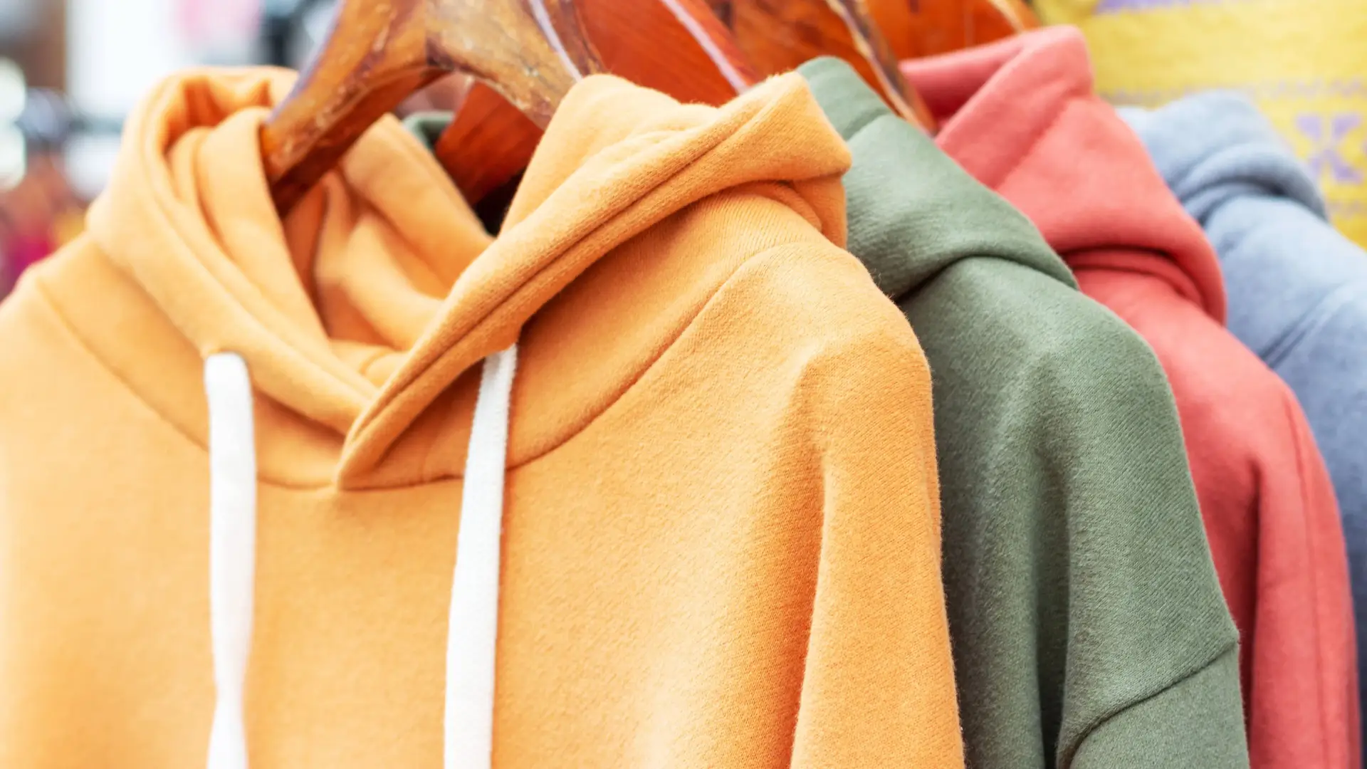 Colorful hoodies & sweatshirts – vibrant selection in detail Colorful sweatshirts on hangers – detailed view of vibrant hoodies, sweaters, and jumpers.